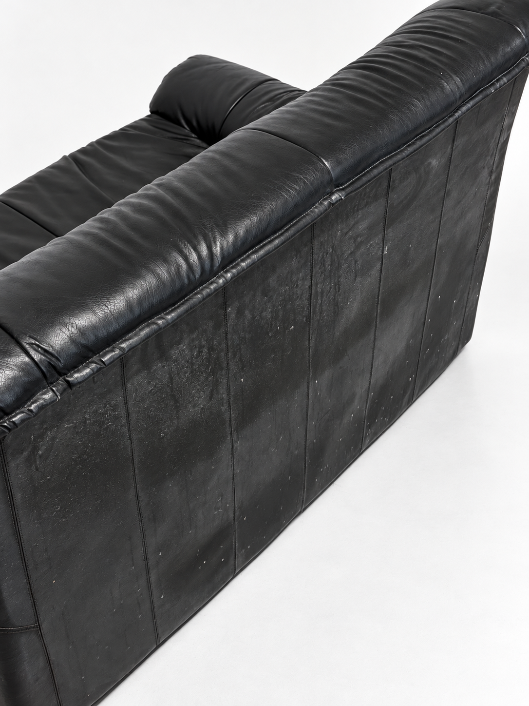 Black leather two-seater sofa, back wear detail
