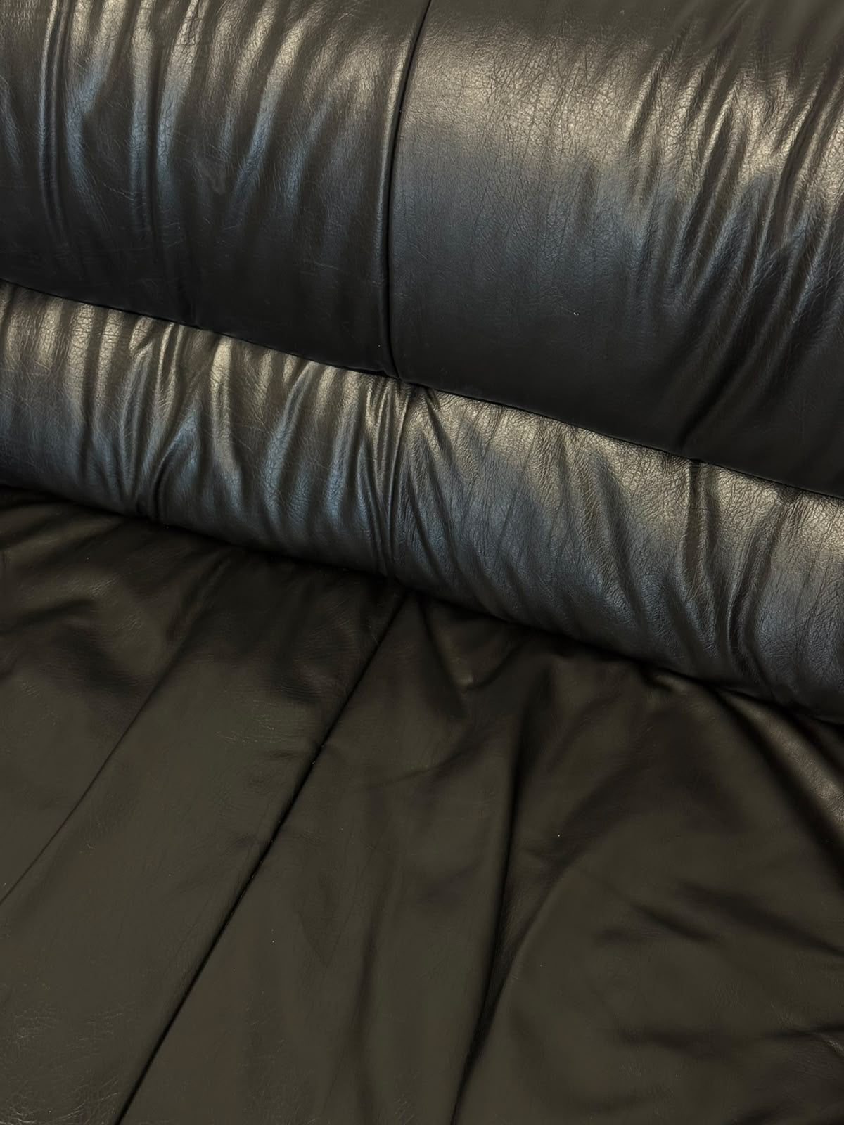 Black leather two-seater sofa, leather close-up