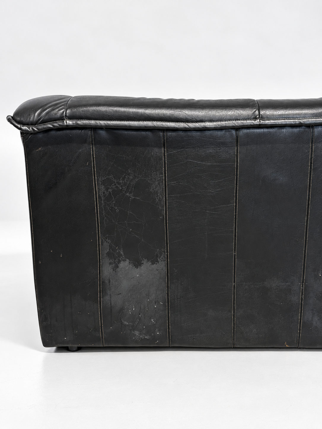 Black leather sofa, back panel wear detail